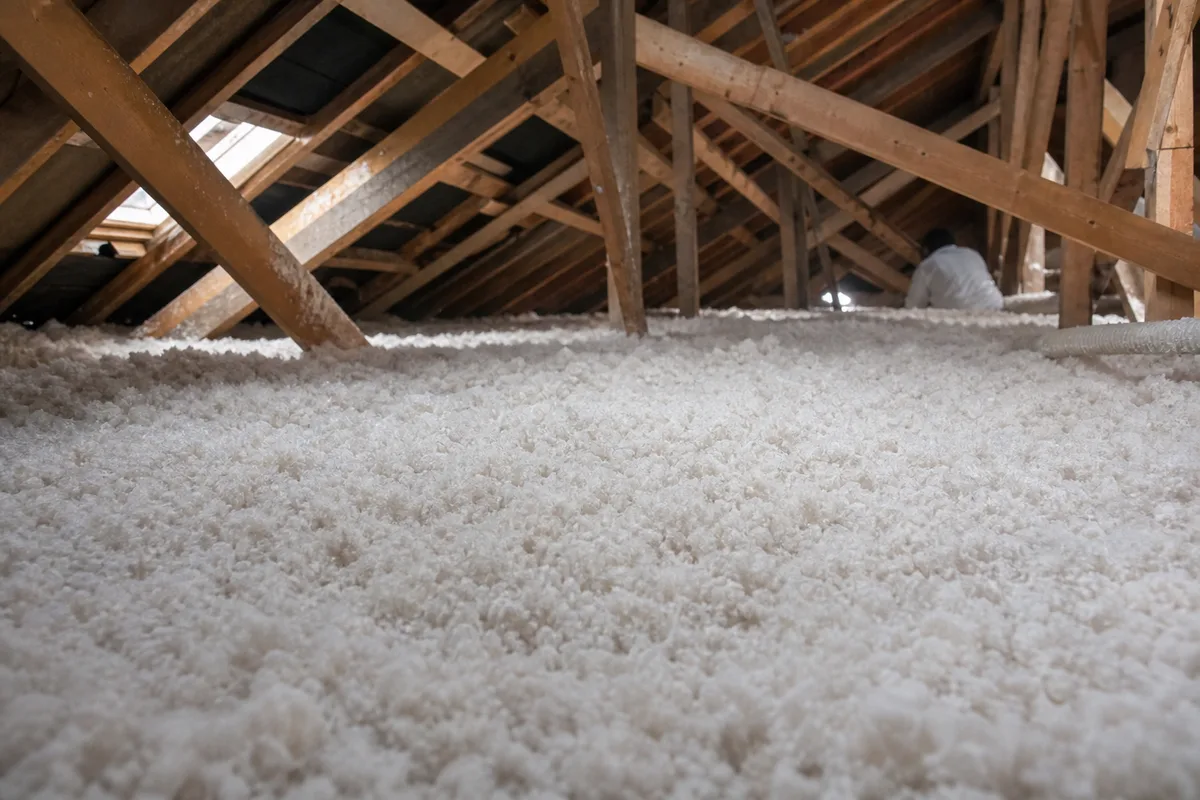 Isolant en flocons soufflé sur le plancher de combles perdus