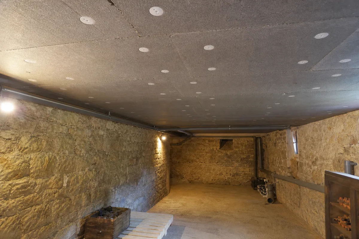 Panneaux isolants fixés en sous-face du plancher d’une cave