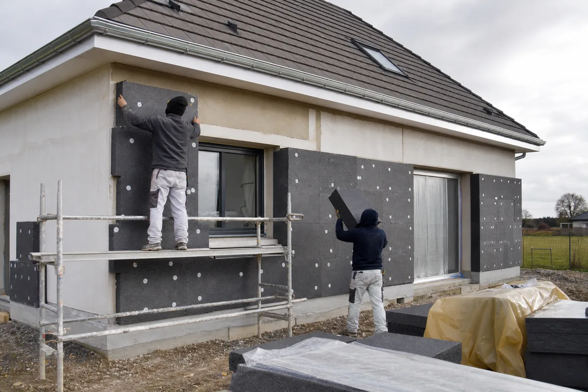 Pose de panneaux isolants sur la façade d’un pavillon avant enduit de finition